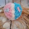 Annonce de douceur avec un cœur décoré de roses blanches et bleues, accompagné de pieds en tissu, créant une ambiance douce et élégante.