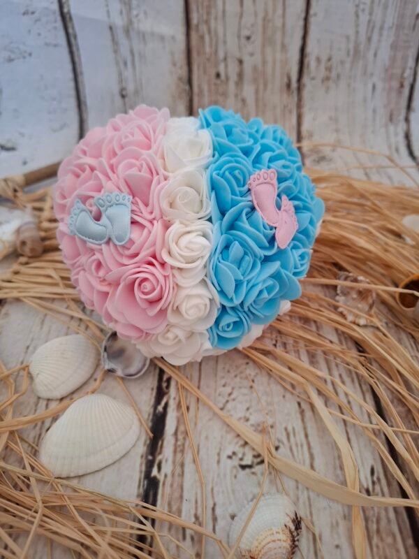 Annonce de douceur avec un cœur décoré de roses blanches et bleues, accompagné de pieds en tissu, créant une ambiance douce et élégante.