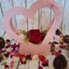 Jardin de cœur avec une boîte en forme de cœur rose, ornée de roses blanches, mousse verte, pivoine rouge, plantes grasses, champignons et paillettes pour une touche magique.