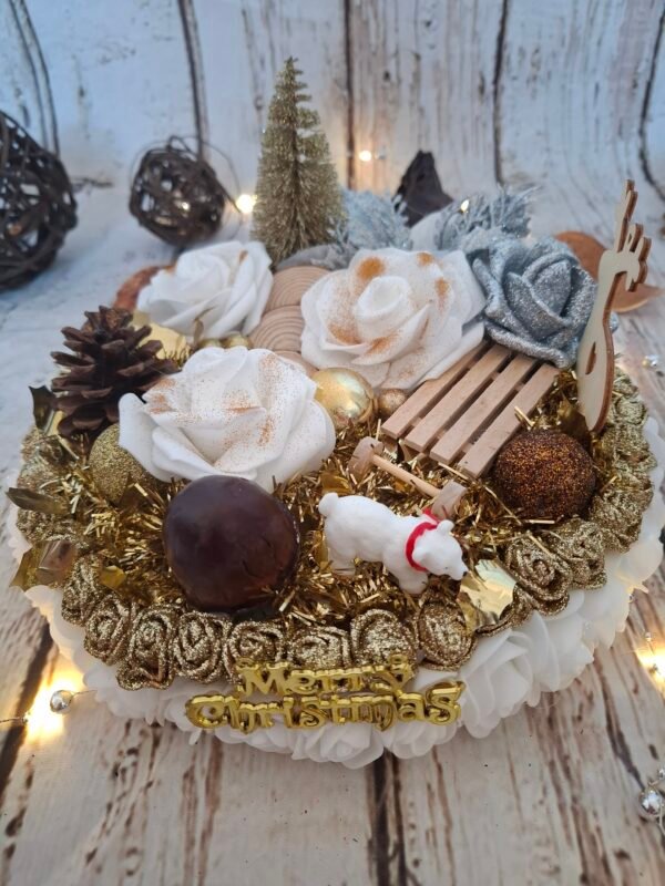 Magie de Noël, un centre de table avec mousse blanche, sapin doré, roses blanches, pomme de pin, luge en bois, cercles, perles dorées pailletées, fleur argentée, boule marron bronze, guirlande, renne, gland et ours polaire.