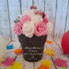 Pot cœur étoilé avec des roses blanches, roses foncées, roses pailletées rose et argent, et un cœur pailleté rose, création florale élégante, romantique et personnalisée.