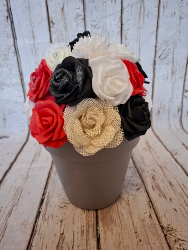 Composition florale Reflets de Passion avec des roses rouges clair, roses noires, roses blanches, roses crèmes strass, hortensias blanches et jute beige.