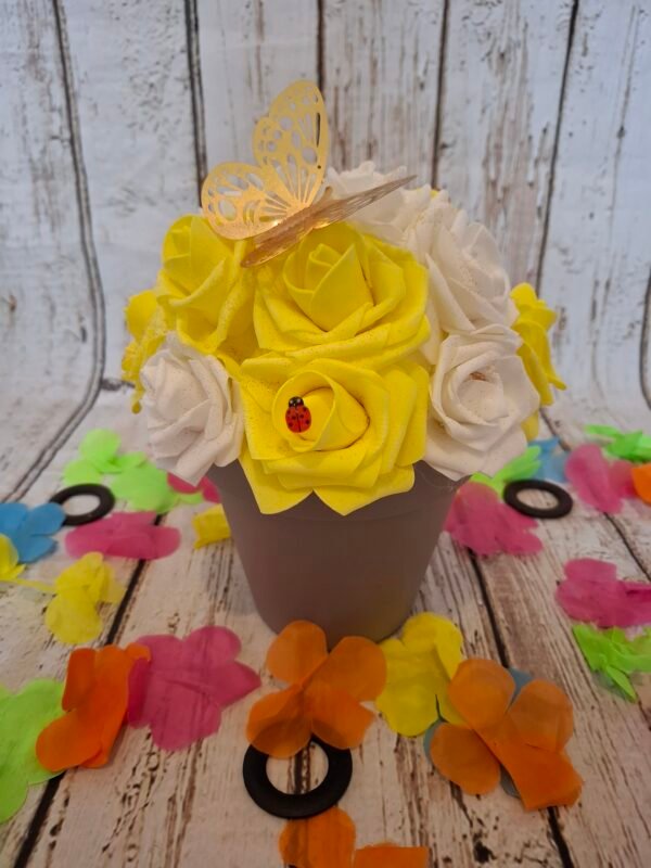 Composition florale Rayon de bonheur avec des roses blanches et jaunes, un papillon doré, des coccinelles et des paillettes.