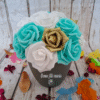 Composition florale Rêve en turquoise avec des roses dorées pailletées, turquoises, blanches et crèmes, avec personnalisation du pot.