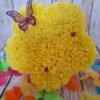 Fleur Timaiika jaune avec mini roses en mousse, décorée de coccinelles et papillon en papier, posée sur support en bois.