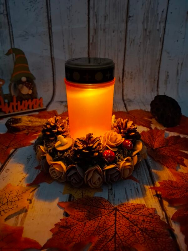 Lanterne solaire florale composée de roses marron et de pommes de pin, idéale pour illuminer une sépulture avec douceur et respect.