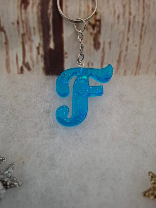 accessoire-personnalise-creatif-elegant-paillettes-003 F en bleu lumineux, petit porte-clés artisanal qui apporte charme et touche unique à votre quotidien.