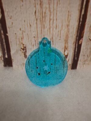 Boule de Noël bleue en résine avec décorations festives, flocons et sapin miniature à l’intérieur.