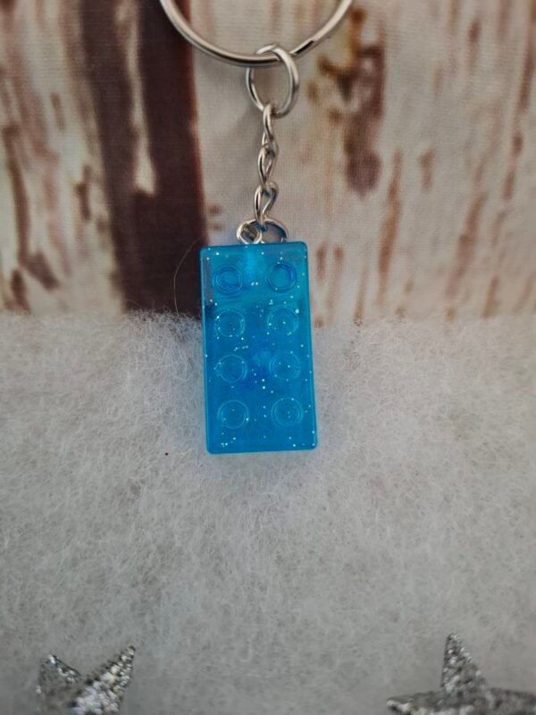 Petit rectangle magique en résine bleue, orné de paillettes scintillantes, mesurant 2,9 cm de hauteur et 1,5 cm de largeur, parfait pour ajouter une touche élégante à vos clés ou sacs.