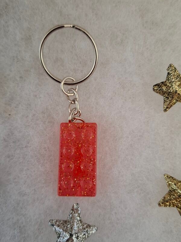 Magnifique porte-clés magique en résine rose, orné de paillettes scintillantes, parfait pour ajouter une touche élégante à vos clés ou sacs.