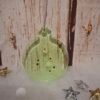 Ornement vert en résine sublimé de paillettes brillantes, imaginé pour l’esprit de fête et prêt à accompagner un joli présent sous le sapin.
