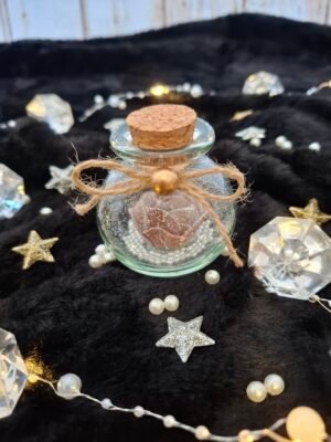 Flacon en verre avec rose chocolat, perles nacrées et paillettes délicates.