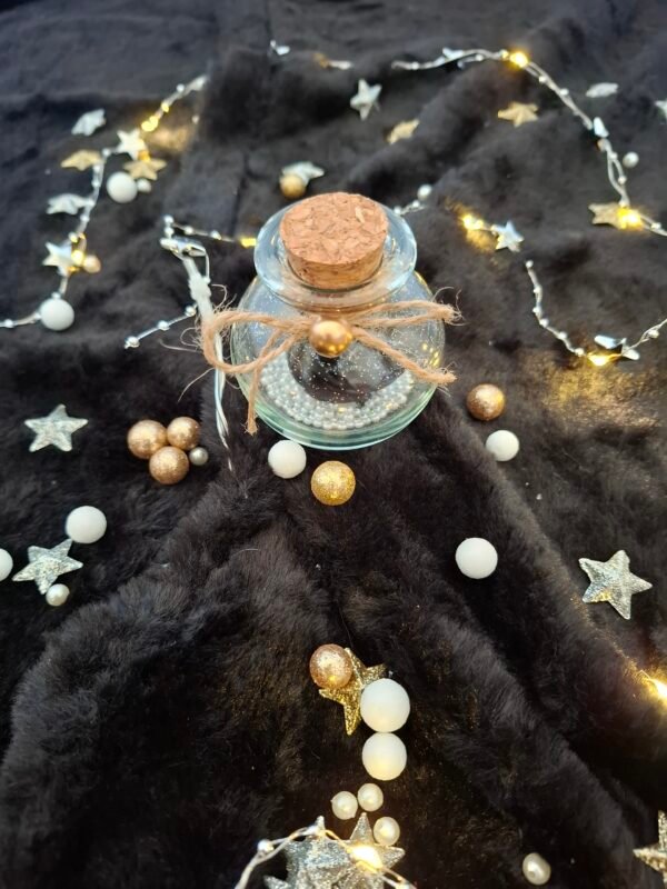 Petite fiole poétique avec rose noire scintillante et ambiance mystérieuse.