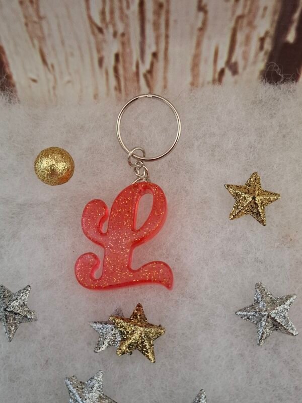 initiale-lettre-prenom-mariage-evenements-anniversaires-001 Lettre L rose en résine, délicatement pailletée, parfaite pour un porte-clés élégant à offrir.