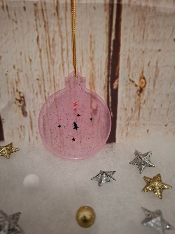 Boule de Noël rose avec détails festifs, paillettes lumineuses et charme féerique.