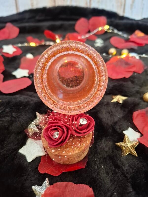 Pot décoratif avec résine transparente teintée, ruban argenté et fleurs délicatement posées.