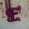 porte-clés-E-résine-artisanale-déco-originale-unique-violette-sac-offrir-001 Lettre E en résine artisanale violette, décorée de paillettes scintillantes, idéale pour un porte-clés élégant.