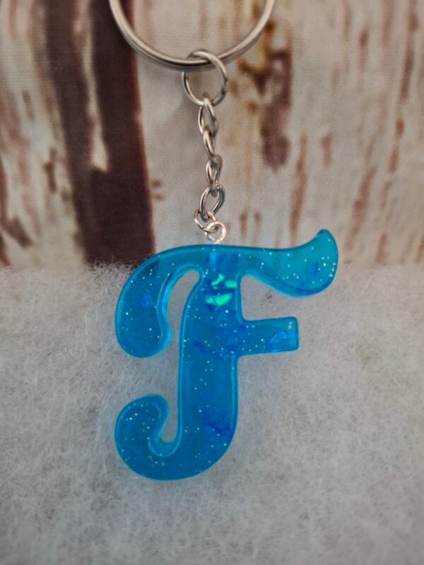 porte-cles-F-resine-artisanale-deco-originale-unique-001 Porte-clés F en résine bleue, décoré de paillettes scintillantes, idéal pour personnaliser sacs et trousseaux avec élégance.