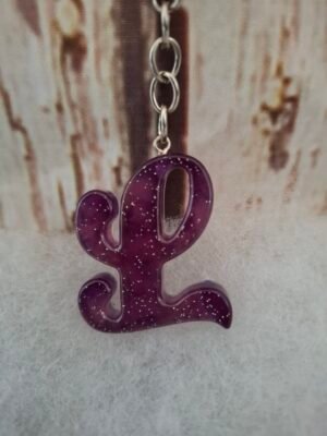 Lettre L en résine, décorée de paillettes scintillantes, idéale pour un porte-clés original et unique.