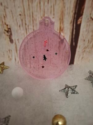 rose-resine-epoxy-noel-fetes-decorations-personnalisation-sapin-001 Boule plate rose en résine avec décorations festives et touches de paillettes brillantes.