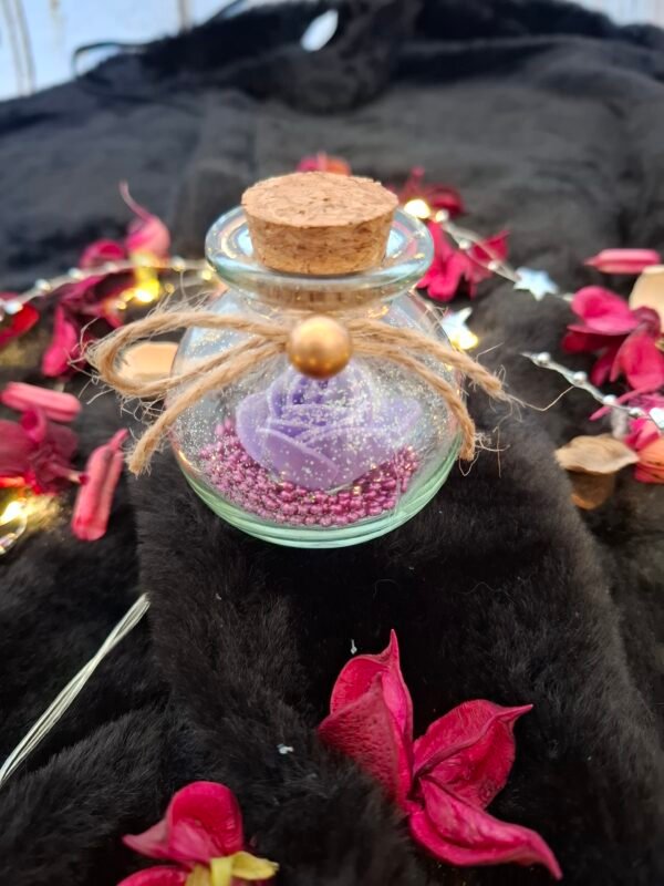 umbra-amethysta-flacon-6cm-rose-violette-paillettes-tamaiika-001 Flacon en verre contenant une rose violette scintillante et des perles assorties.