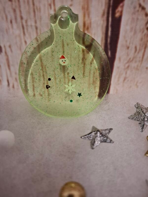 Création artisanale verte en résine, décorée pour Noël avec de fines paillettes et une touche festive idéale pour offrir en cadeau.