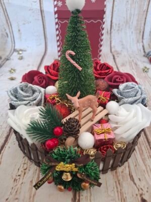 centre-table-decorations-noel-fetes-creations-sapin-001 Centre de table Douce Nuit de Noël avec sapin vert pailleté, roses blanches, rouges et bordeaux, décorée de boules dorées et rouges scintillantes, mini biche et luge, couronne et bouquet de gui, ambiance festive et élégante.