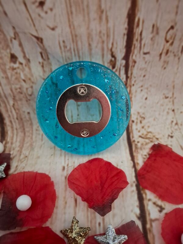 Décapsuleur artisanal “Déclic & Chin” en résine ronde, d’environ 7 cm de diamètre, avec inclusions décoratives uniques.