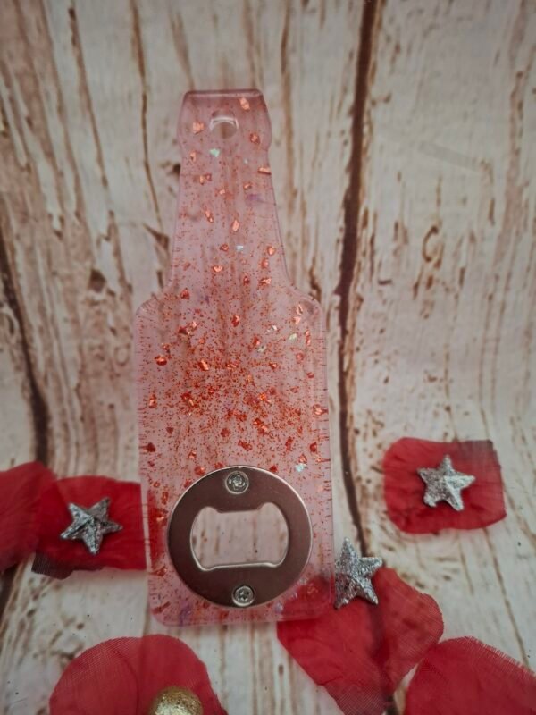 decapsuleur-deco-personnalise-paillete-resine-bijou-artisanat-unique-cadeau-surprise-004 Décapsuleur rouge-rose fait main, design en forme de bouteille, combinant utilité et touche festive pour vos soirées et apéritifs.
