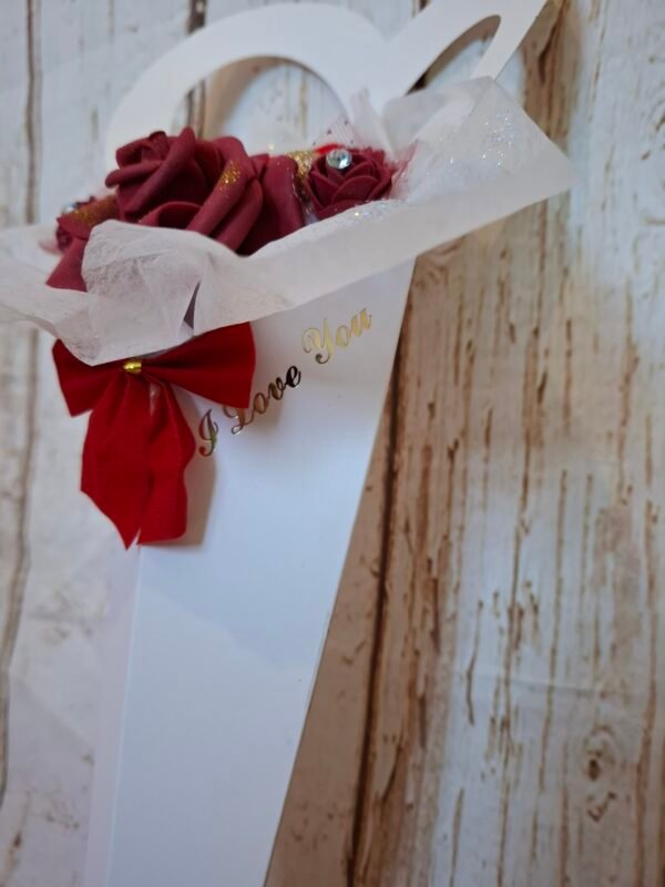 iloveyou-personnalisation-timaiika-artisanat-creations-004 Élégante composition florale dans un cornet en forme de cœur, rose en mousse burgundy et mini-roses délicatement décorées de dentelle et strass, sur papier de soie scintillant.
