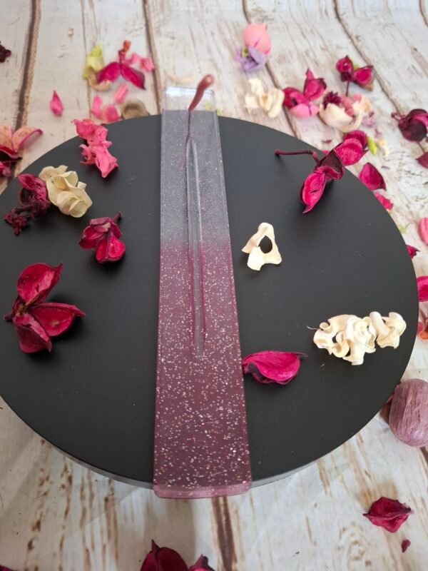 Support pour bâtonnets d’encens en résine rose transparente avec touches scintillantes, design élégant et fonctionnel.