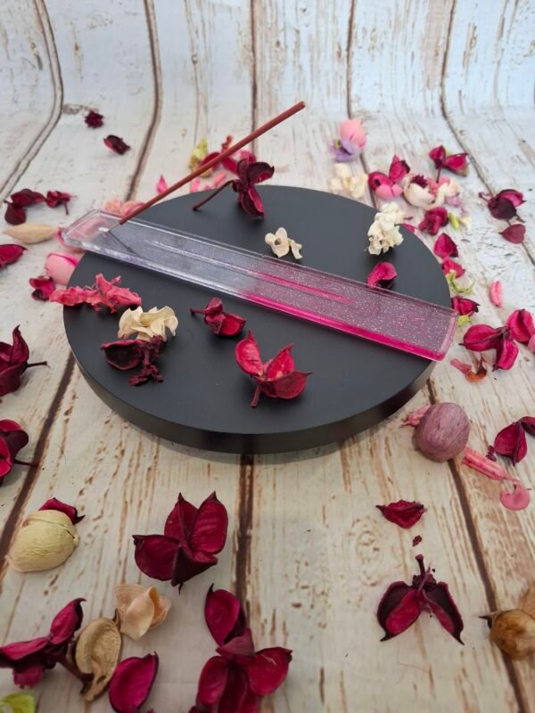 Porte-encens en résine rose, agrémenté de paillettes brillantes, idéal pour poser vos bâtonnets avec style.