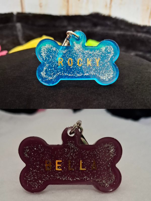Médaillon personnalisable en résine époxy pailletée bleu et violet, pouvant servir de porte-clés en forme d’os, avec prénom d’animal, accessoire léger pour chien ou chat à accrocher au collier ou à un sac.