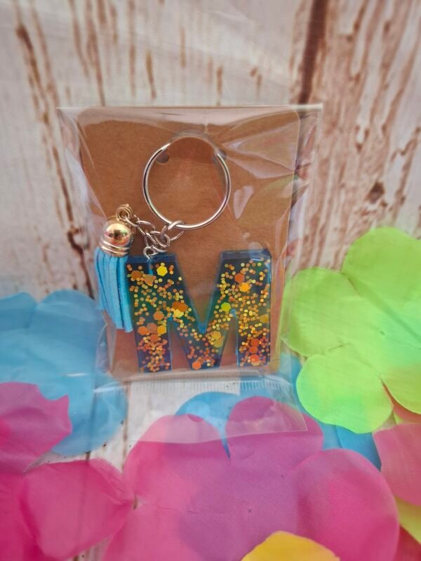emballage-expédition-cadeau-flower-creatrice-alphabet-lettres-initiales-prenoms-006 Lettre M Mystéa, petit porte-clés en résine bleu clair avec paillettes dorées et pompon multicolore, bijou original et élégant à offrir ou garder comme souvenir personnalisé.