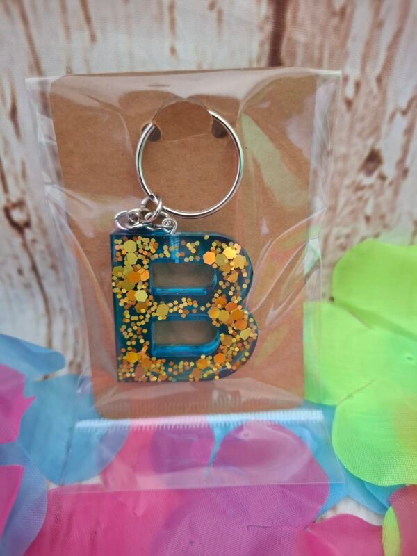 emballage-homme-femme-choix-resine-anniversaire-noel-bapteme-mariage-006 Modèle B en Balyséa, pièce artisanale en résine bleue avec incrustations scintillantes et attache porte-clés raffinée.