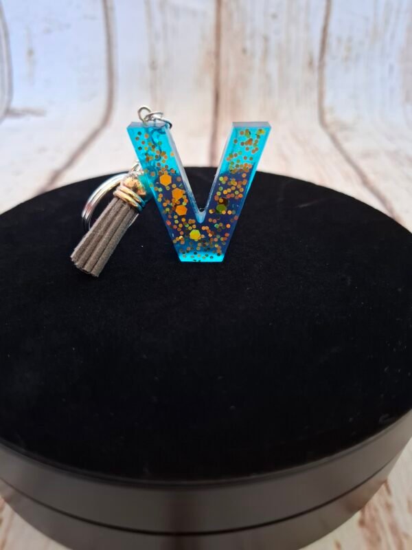 Initiale en matière colorée verte, légère et originale, pensée pour hommes cherchant un accessoire unique.