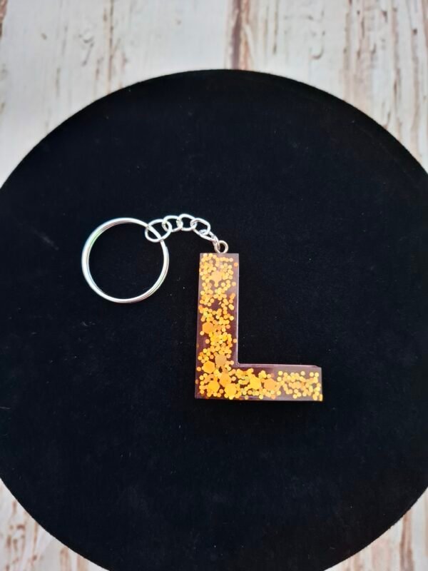 femmes-rose-paillettes-dorees-pompon-cadeaux-anniversaire-noel-anneaux-002 Création artisanale représentant l’initiale L, avec un effet lumineux et des reflets dorés, parfaite pour personnaliser vos affaires du quotidien avec style.