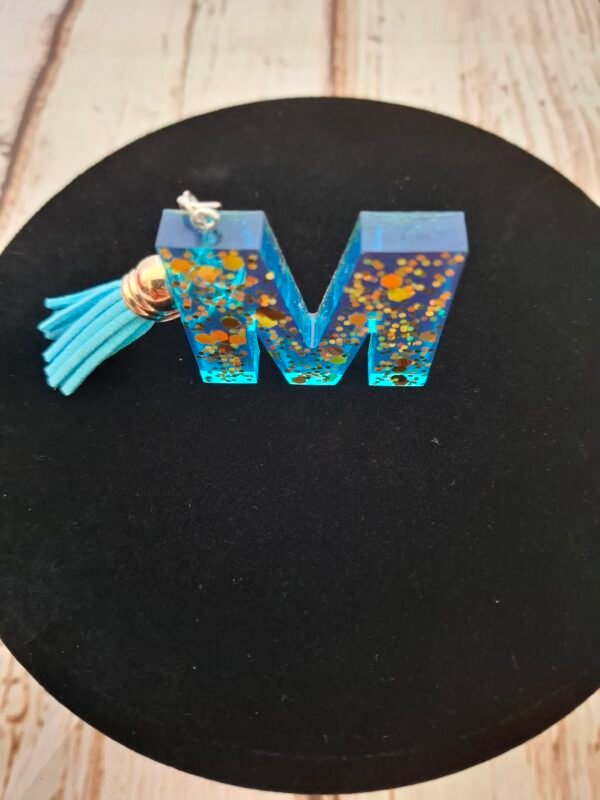 floral-artisanal-pompon-crochets-anniversaire-noel-fetes-des-meres-004 Accessoire unique lettre M, résine bleu lumineux parsemée d’éclats dorés, montée sur mousqueton et anneau, parfait pour un cadeau Saint-Valentin, Noël ou pour homme et femme.