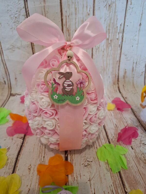 Petite merveille girly, décorée de roses miniatures roses et blanches, fermée grâce à un ruban noué et aimants discrets, rehaussée d’un pendentif en bois représentant un lapin.