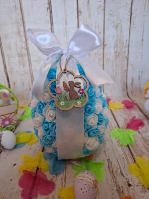 Œuvre artisanale Sucré Bleu en polystyrène, ornée de mini-fleurs blanches et azurées, avec un petit ourson suspendu en bois gravé.