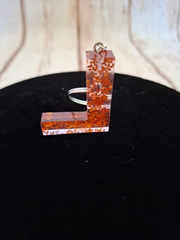 offert-expedition-lettres-initiales-qualite-brillant-lumineux-004 Porte-clés unique représentant l’initiale L, réalisé dans une résine éclatante, complété par un petit pompon pour un effet chic et raffiné.