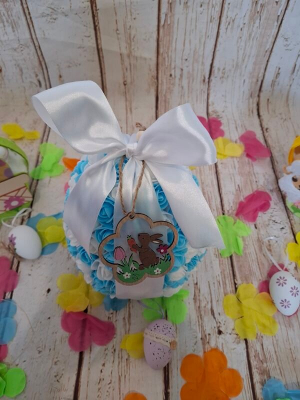 Élément de décoration raffiné, décoré de fleurs fines et d’une douceur sucrée, complété par un charmant lapin en bois.