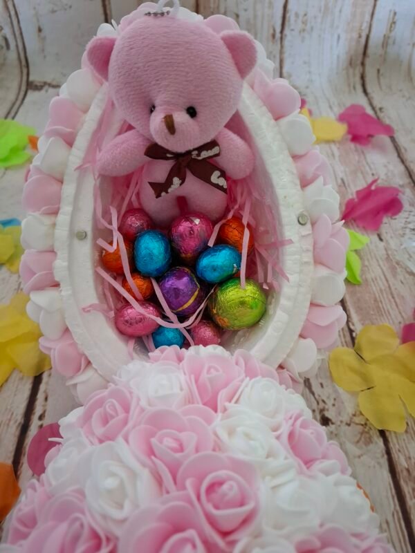 Fantaisie printanière : œuf blanc et rose décoré de mini-fleurs, avec fermeture pratique grâce à de petits aimants et un pendentif en bois raffiné représentant un petit lapin.