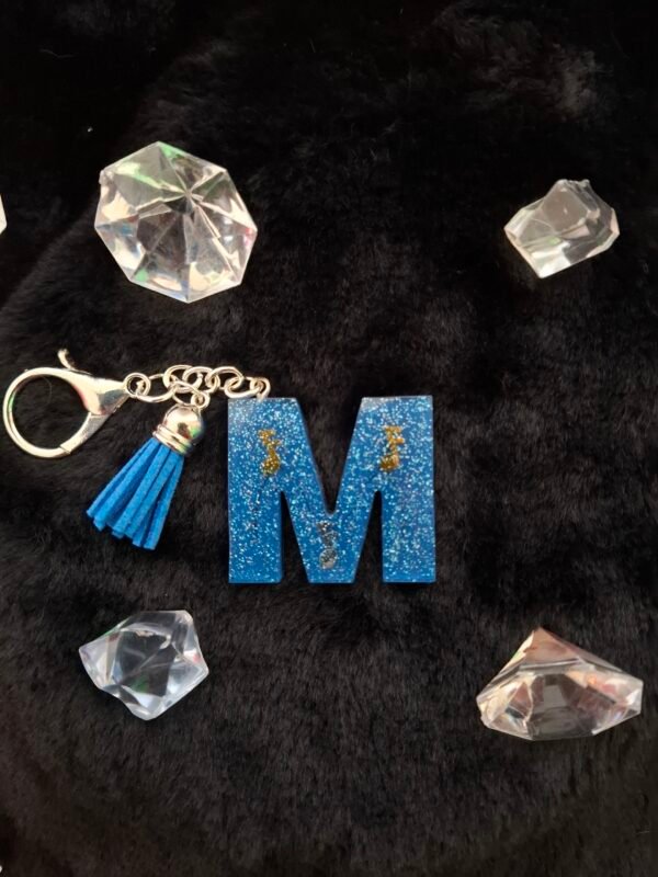 bleu-argente-dore-pompon-fetedesmeres-anniversaires-musical-timaiika-002 Accessoire alphabet bleu outremer avec un petit pompon, idéal pour accrocher à un sac ou un trousseau lors d’un anniversaire.