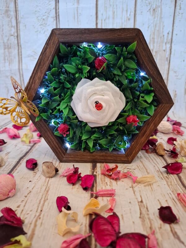 La composition est mise en valeur par une guirlande LED douce, réglable grâce à un bouton discret situé à l’arrière.