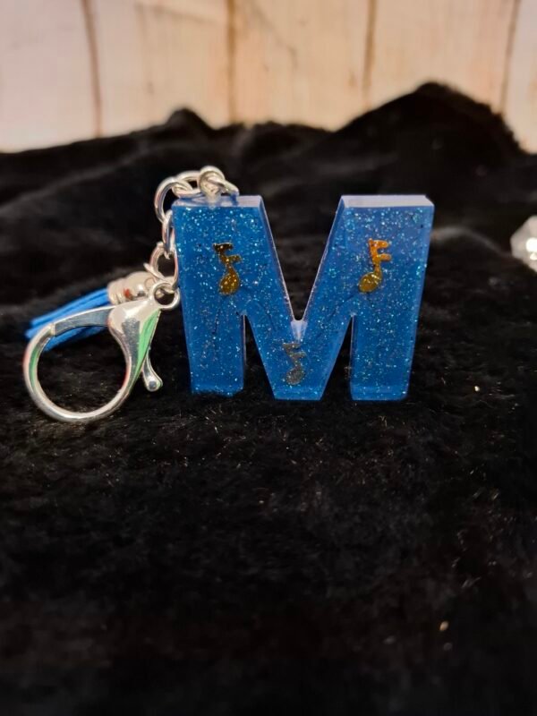 mousqueton-anneaux-emballage-resine-leger-lettres-m-couleurs-003 Création unique intégrant des formes scintillantes de notes musicales, un bijou de sac raffiné pour la fête des mères.